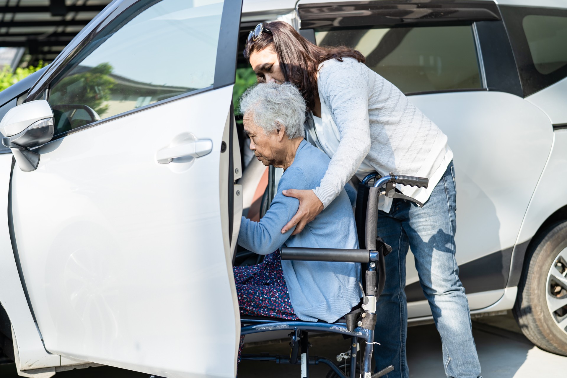 Asian senior or elderly old lady woman patient sitting on wheelchair prepare get to her car, healthy strong medical concept.